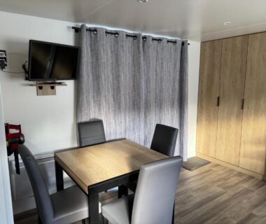 Intérieur coin repas avec table et chaises dans le Mobilhome camping le BOSC
