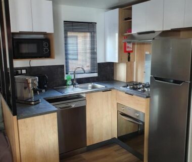 Cuisine équipée avec réfrigérateur et micro-ondes dans le Mobilhome camping le BOSC
