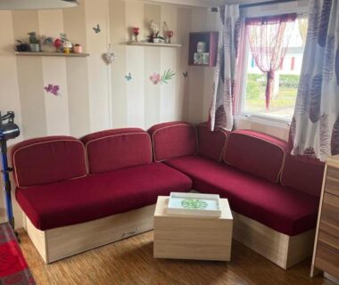 Salon avec banquette rouge dans le Mobilhome camping proche des plages