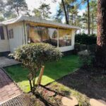Jardin et terrasse abritée devant un mobilhome sous les pins du Mobilhome climatisé 6 personnes camping les Embruns