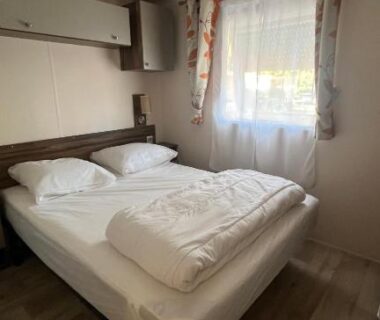 Chambre avec lit double et fenêtre dans le mobilhome climatisé du camping les embruns