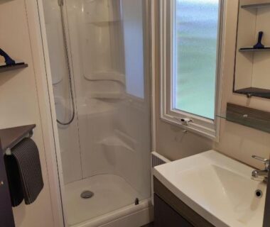Salle de bain avec douche et lavabo dans le mobilhome cosy spacieux au bord de l'Eure