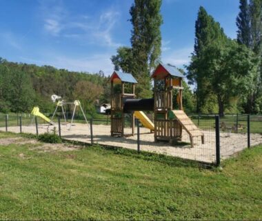 Aire de jeux du camping avec structures en bois et balançoires au Mobilhome cosy, spacieux au bord de l’Eure