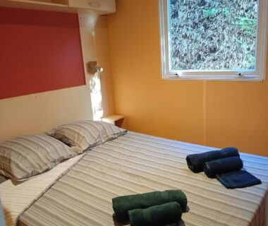 Chambre avec lit double et serviettes dans le mobilhome du camping 3 étoiles en Provence