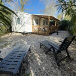 Cour gravillonnée avec transats devant Mobilhome dans camping 3 étoiles en Provence