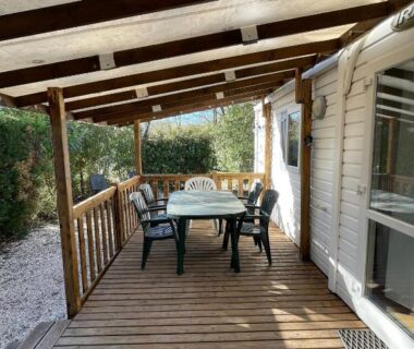 Terrasse couverte avec table et chaises du mobilhome dans camping 3 étoiles en Provence