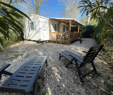Cour gravillonnée avec transats devant Mobilhome dans camping 3 étoiles en Provence