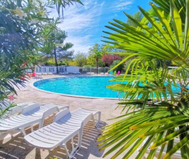 Piscine ronde et transats au soleil devant le Mobilhome dans camping 3 étoiles en Provence