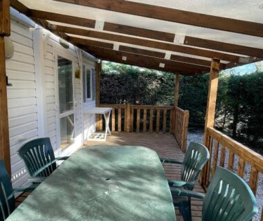Terrasse couverte avec table et chaises du mobilhome dans camping 3 étoiles en Provence