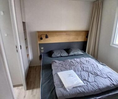 Chambre avec lit double et fenêtre dans le Mobilhome dans les Pins
