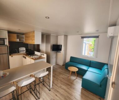Séjour avec kitchenette et canapés du mobilhome dans les pins au Camping Les Oyats