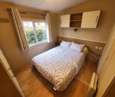 Chambre avec lit double et fenêtre dans le mobilhome de 45 m2 au Camping siblu La Réserve 4****