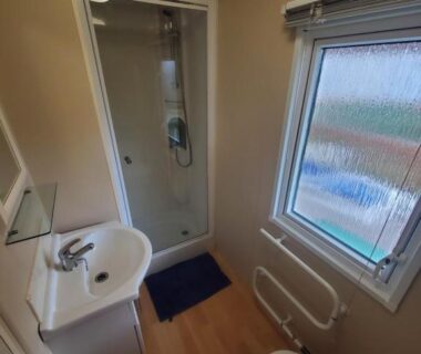Salle de bains avec douche et fenêtre dans le mobilhome de 45 m2 au Camping Siblu La Réserve