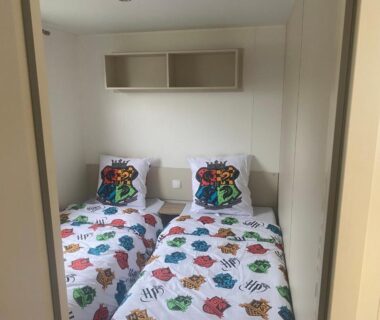 Intérieur de la chambre avec deux lits jumeaux et rangements du Mobilhome élégance
