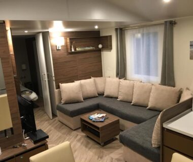 Salon avec canapé d'angle et coin repas dans le Mobilhome familial Saint Brévin Les Pierres Couchées
