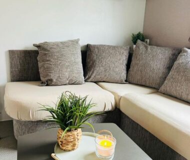 Salon avec canapé d'angle et table basse dans le mobilhome la Carabasse 40m2 6-8 personnes