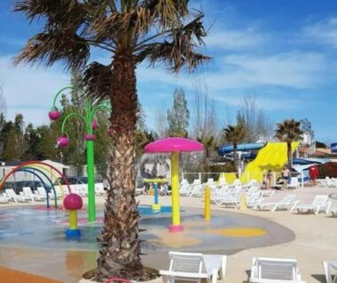 Espace aquatique avec palmiers toboggans et transats au Mobilhome la Carabasse 40m2 6-8 personnes