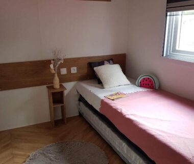 Chambre avec lit simple et fenêtre dans le mobilhome la carabasse