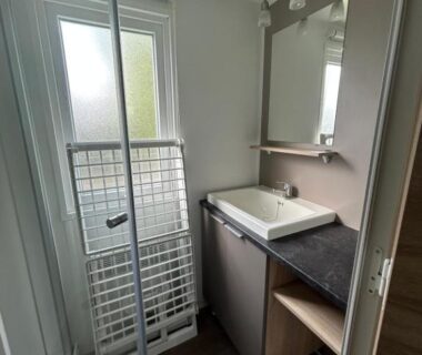Salle de bain avec lavabo et miroir du Mobilhome les 3C de mimizan