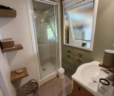 Salle d'eau avec cabine de douche et lavabo dans le mobilhome les pieds dans l eau avec piscine