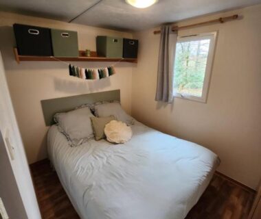 Chambre avec lit double et fenêtre dans le mobilhome les pieds dans l eau avec piscine
