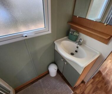 Salle d'eau avec lavabo miroir et fenêtre dans le mobilhome les pieds dans l eau