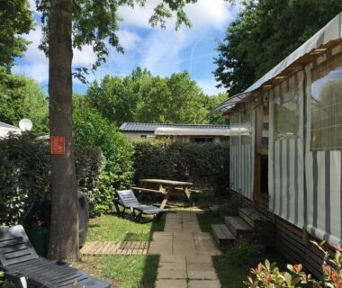Coin détente avec transat et table de pique-nique du Mobilhome neuf au camping La Réserve