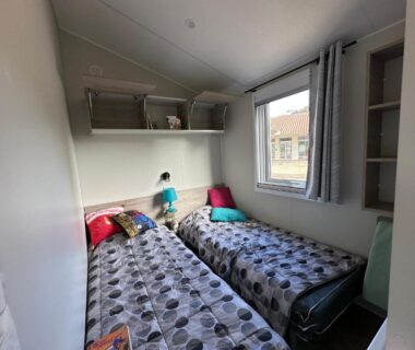 Chambre avec deux lits simples et étagères dans le mobilhome neuf au camping La Réserve