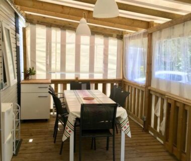 Terrasse couverte avec table et chaises du mobilhome neuf au camping La Réserve