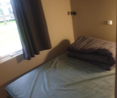 Chambre avec lit et fenêtre dans le Mobilhome proche Puy duFou