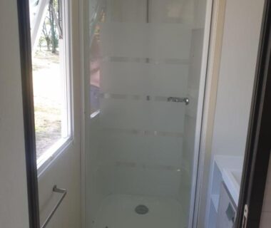 Salle d'eau avec cabine de douche et fenêtre dans le Mobilhome proche Puy duFou