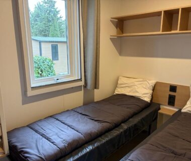 Chambre avec deux lits simples et fenêtre dans le Mobilhome proche de la mer 6pers 3ch