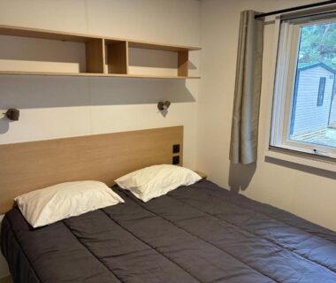 Chambre avec lit double et fenêtre donnant sur l'extérieur du mobilhome proche de la mer 6pers 3ch