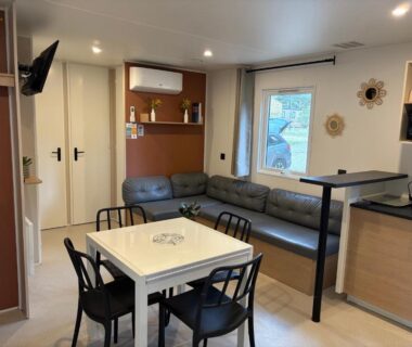 Salon avec banquette table et kitchenette dans le Mobilhome proche de la mer 6pers 3ch