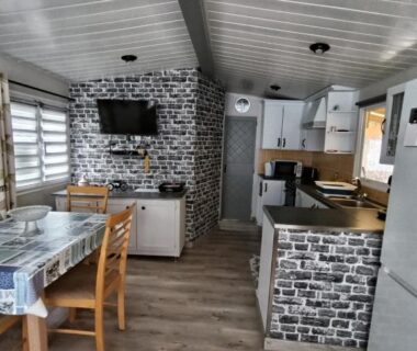 Intérieur avec cuisine coin repas et télévision du Mobilhome rénové climatisé 10min plage Mimizan