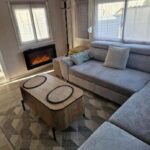 Salon avec canapé et cheminée dans le mobilhome spacieux