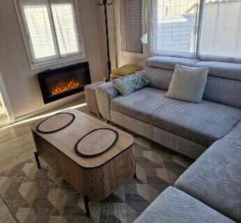 Salon avec canapé et cheminée dans le mobilhome spacieux