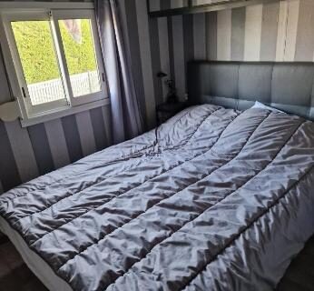 Chambre avec lit double et fenêtre dans le Mobilhome spacieux