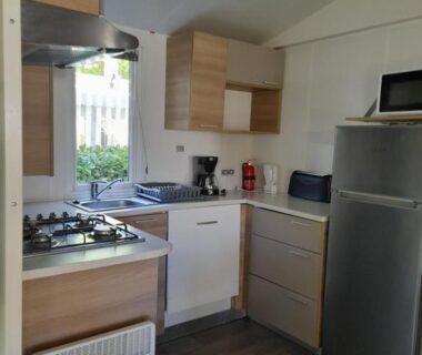 Cuisine équipée avec plaque et réfrigérateur dans le mobilhome spacieux MH580 3ch et grande terrasse