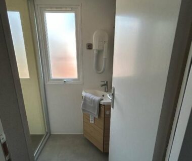 Salle de bain avec lavabo douche et sèche-cheveux du Mobilhome sur camping 4 étoiles