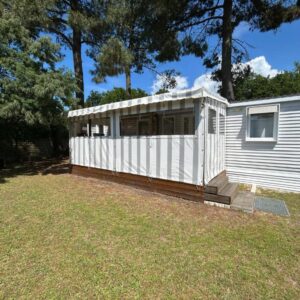 Extérieur d'un mobilhome sur pelouse sous les pins au Mobilhome sur camping 4 étoiles