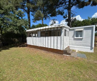 Extérieur d'un mobilhome sur pelouse sous les pins au Mobilhome sur camping 4 étoiles