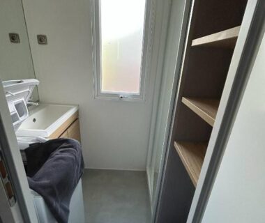 Salle d'eau avec lavabo et étagères dans le mobilhome sur camping 4 étoiles