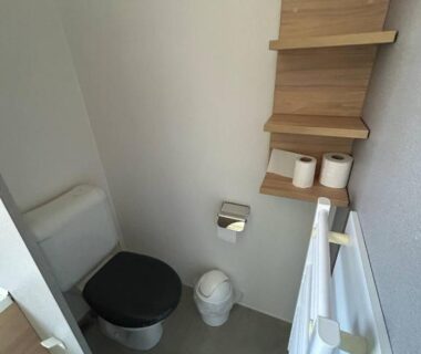 WC compact avec étagères et radiateur dans le Mobilhome sur camping 4 étoiles