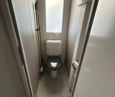 WC compact avec fenêtre et couloir dans le mobilhome sur camping 4 étoiles