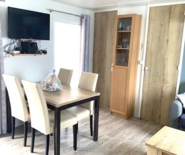 Séjour avec table chaises et télévision du Mobilhome tout confort 40 m2 pour 4 personnes