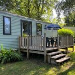 Terrasse en bois avec table chaises et parasol au mobilhome tout confort M9 domaine de Lanniron