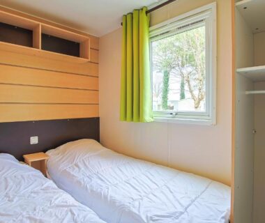 Chambre avec deux lits et fenêtre dans le Mobilhome tout équipé bois masson