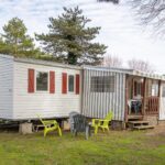 Devant le mobilhome pelouse chaises et terrasse du Mobilhome tout équipé bois masson