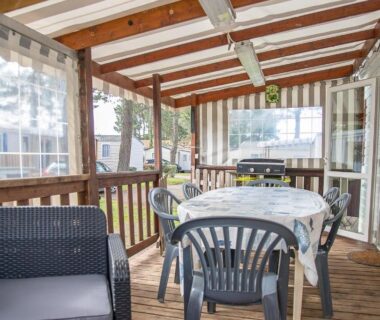 Terrasse couverte avec table chaises et barbecue du Mobilhome tout équipé bois masson